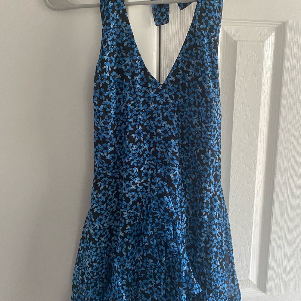 NWOT Mini halter dress with blue flowers on a black background.